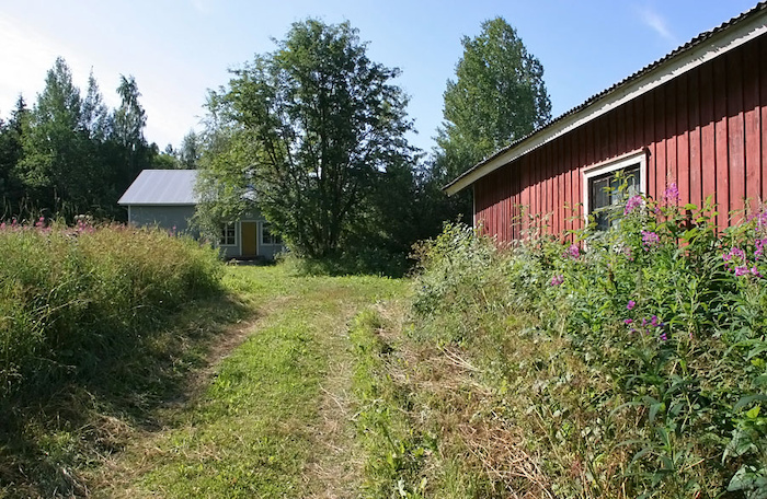 Suuri ulkorakennus yleisen tien liittymän luolta nähtynä, tässä kulmassa näyttää olevan puucee